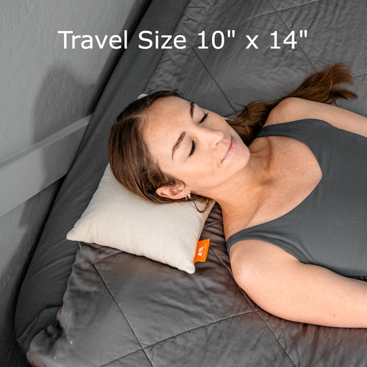 Classic Japanese Sobakawa buckwheat pillow travel size with a young woman sleeping on it