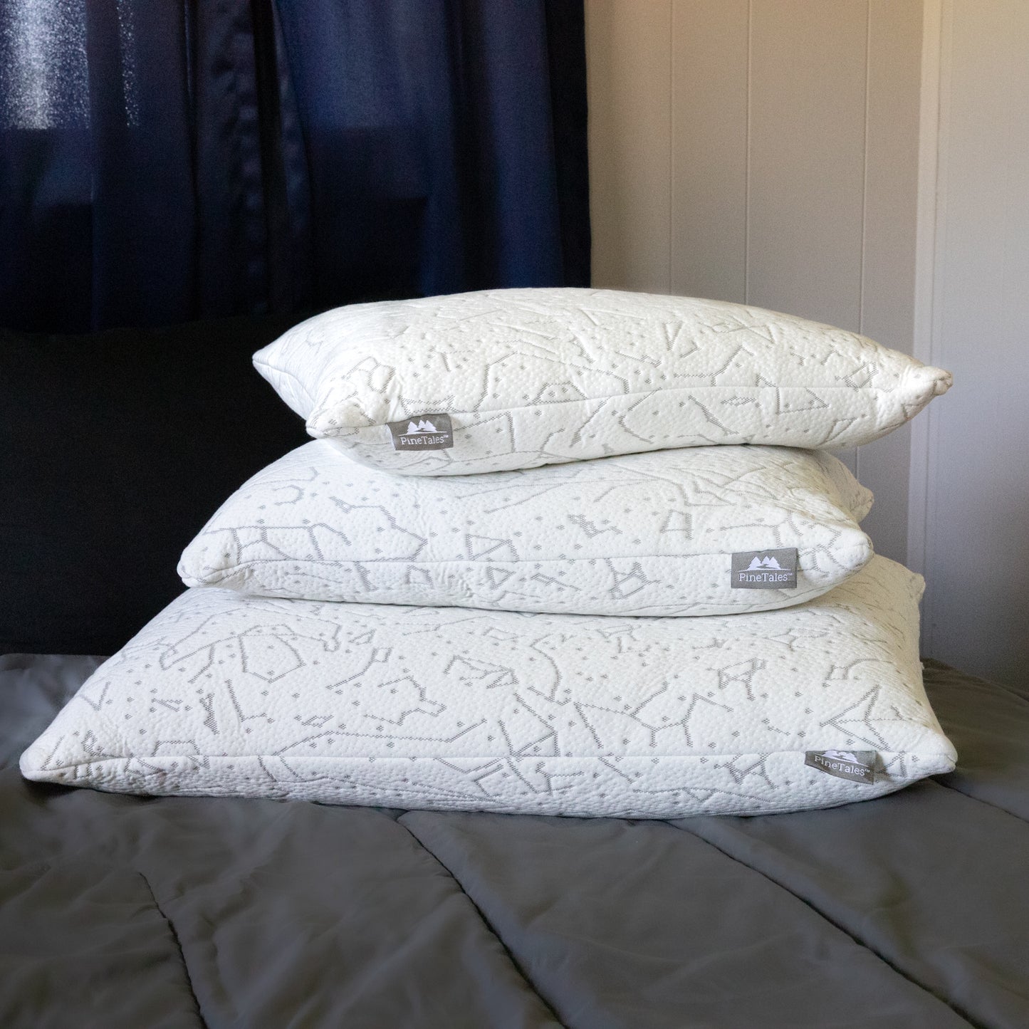 Various sizes and models of a pinetales platinum buckwheat pillows arranged neatly on a bed