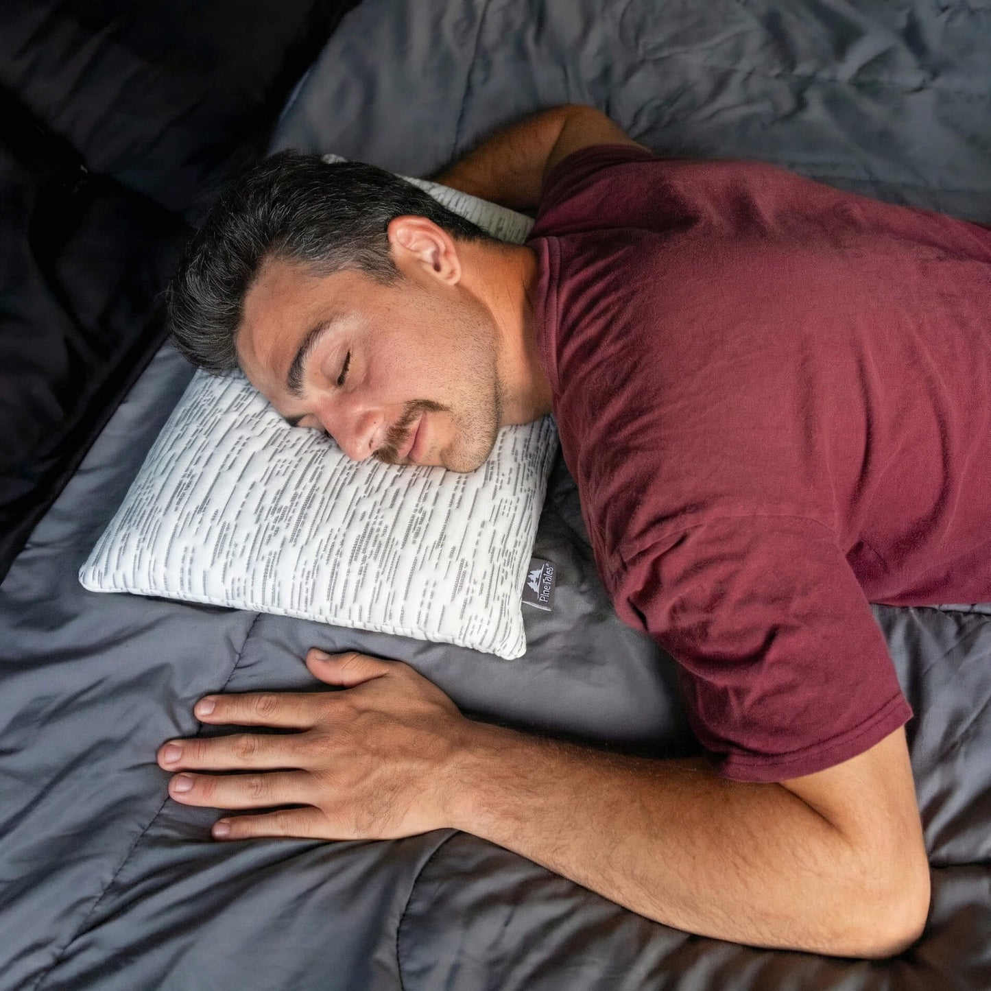 Young man using stomach sleeper pillow with matrix design bamboo cover